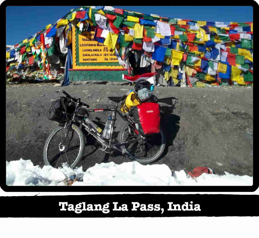 Left side view of a black Surly Long Haul Trucker bike, loaded with gear, on snow-Taglang La Pass, India tag below image