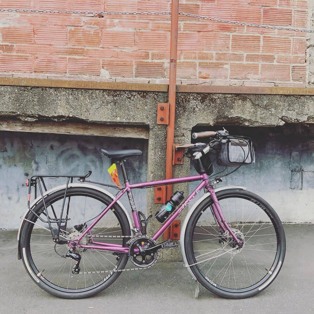 Right side of Surly Straggler bike colored in Glitter Dreams in front of a brick and concrete structure 