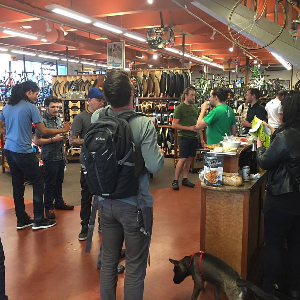 A group of people standing around, in a bike shop