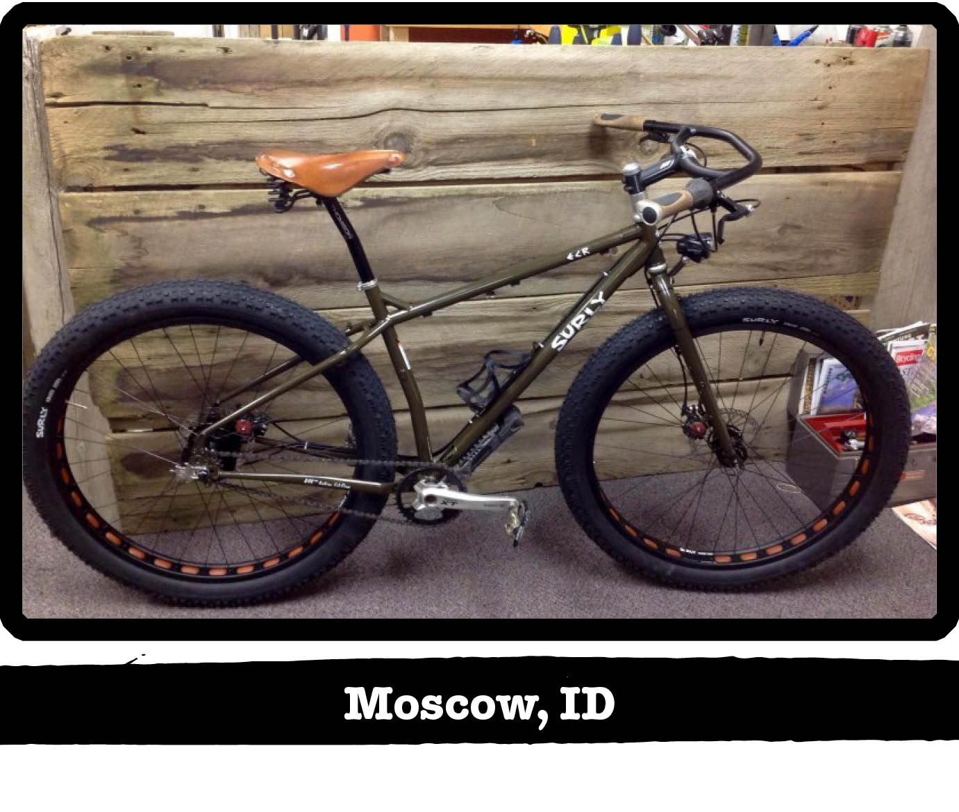 Right side view of a Surly ECR fat bike, olive drab, against a wood wall - Moscow, ID tag below image