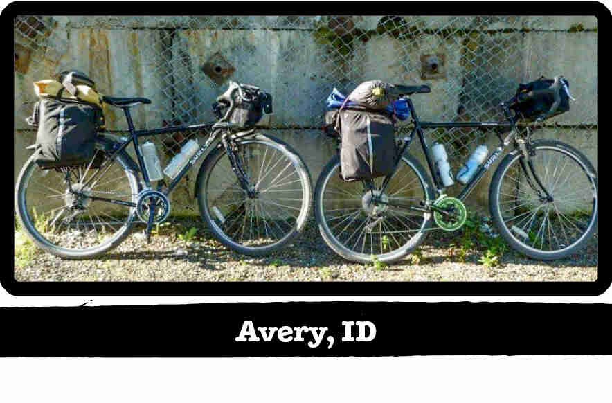 Right side view of 2 Surly bikes leaning on a chain link fence - Avery, ID tag below image