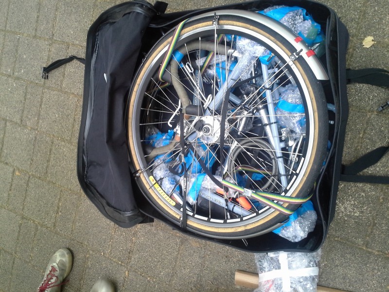 Downward view of a disassembled bike, packed inside of an open bike travel bag