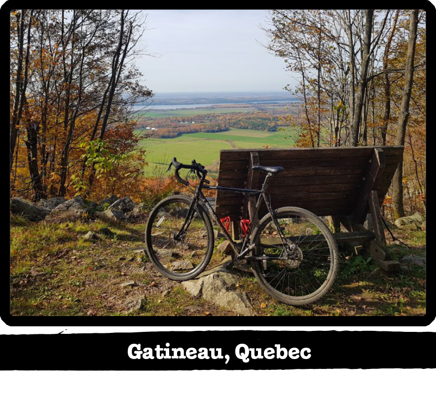 Left profile of a Surly bike leaning on a park bench overlooking a green valley-Gatineau, Quebec banner under image