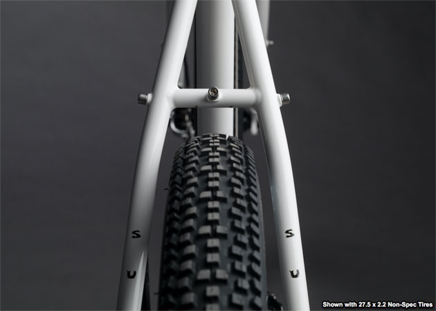 Zoomed in rear view of a the seat tube, seat stay and top of a tire, of a Surly Midnight Special bike, white