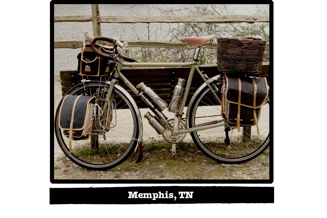 Left side view of a Surly bike leaning on a park bench, with a wood railing in background - Memphis, TN tag below image