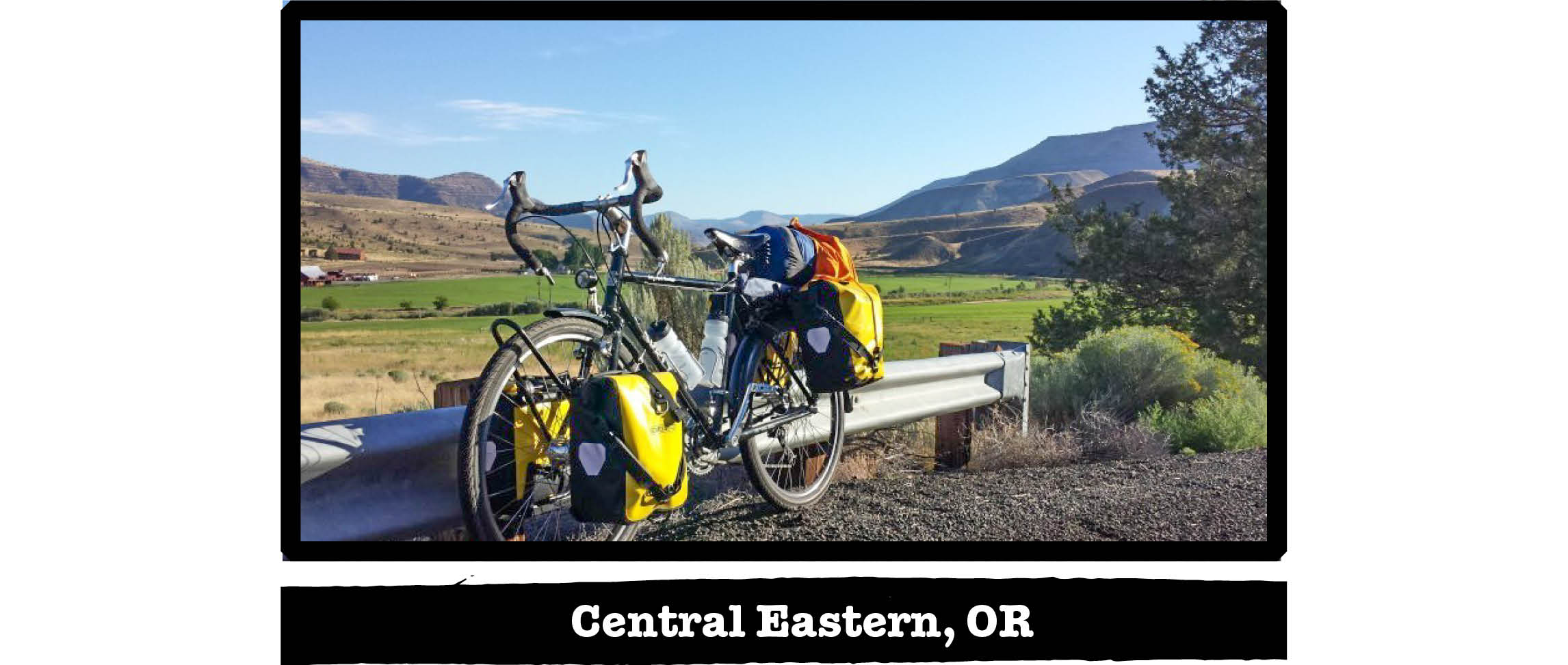 Left side view of a Surly Long Haul Trucker bike, along a rail with hills behind - Central Eastern, OR tag below image