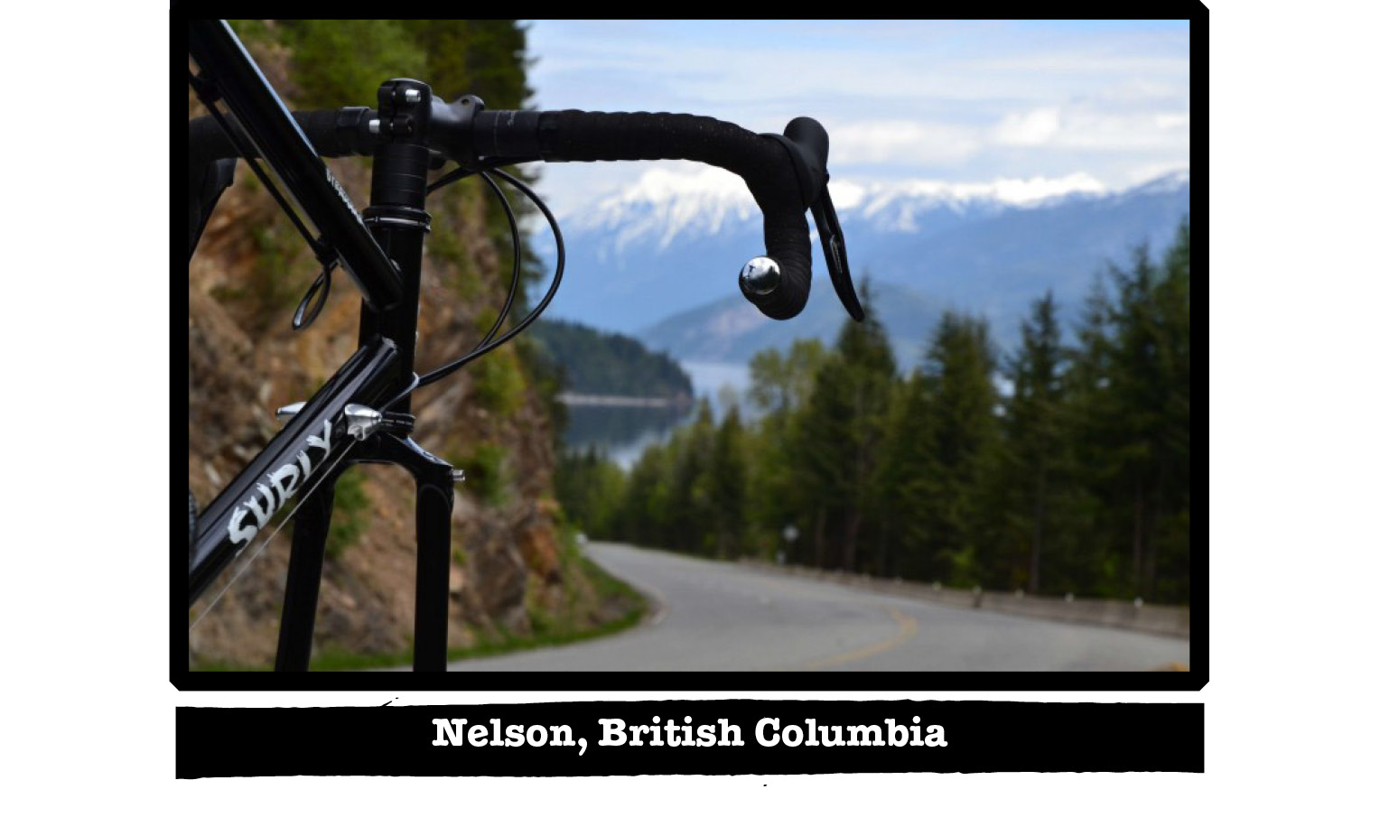 The front of a Surly bike facing down a hill on a paved road in the mountains - Nelson, British Columbia tag below image