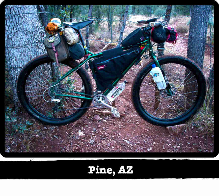 Right side view of a green Surly bike with gear, on red gravel in the woods - Pine, AZ tag below image