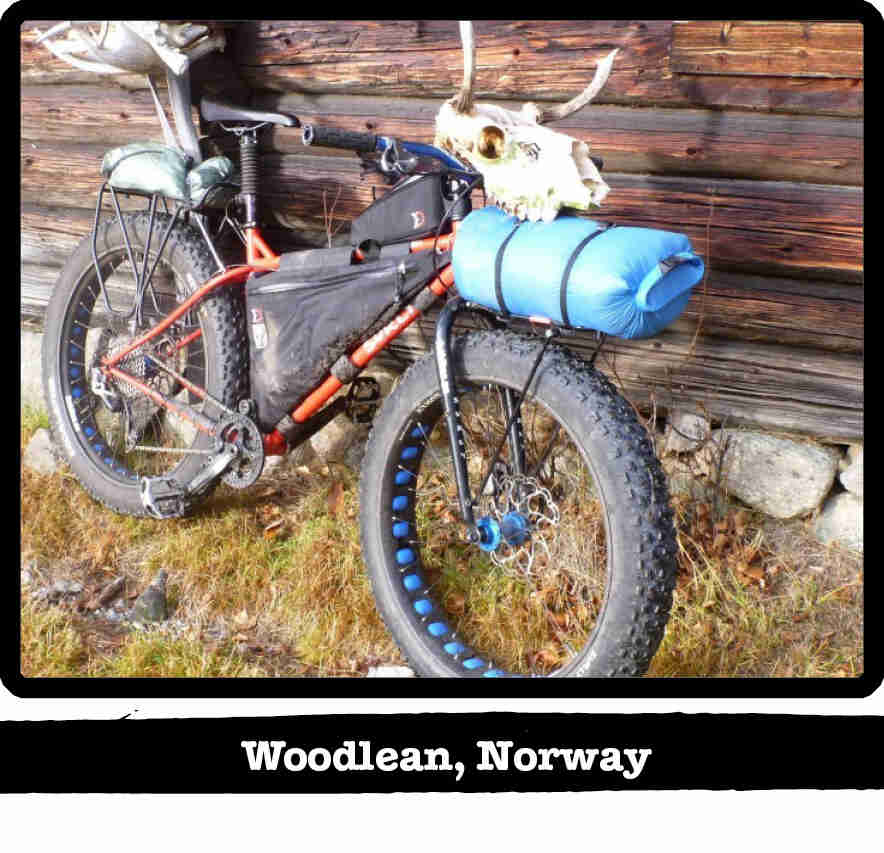 Right side view of an orange Surly fat bike with gear and a bull skull on the handle - Woodlean, Norway tag below image