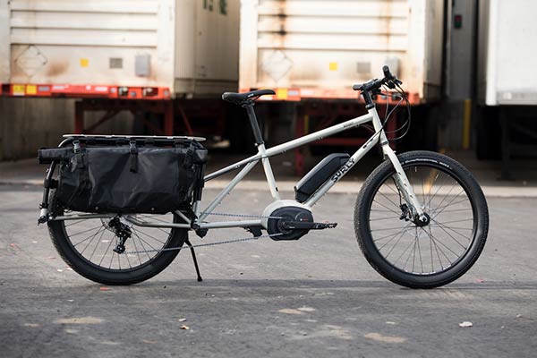 Right side view of a white Surly Big Easy bike with rear saddle bags upright on pavement