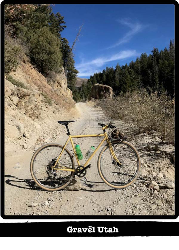 Right profile of a Surly bike standing across a gravel trail with hills and pines behind-Gravel Utah banner below image
