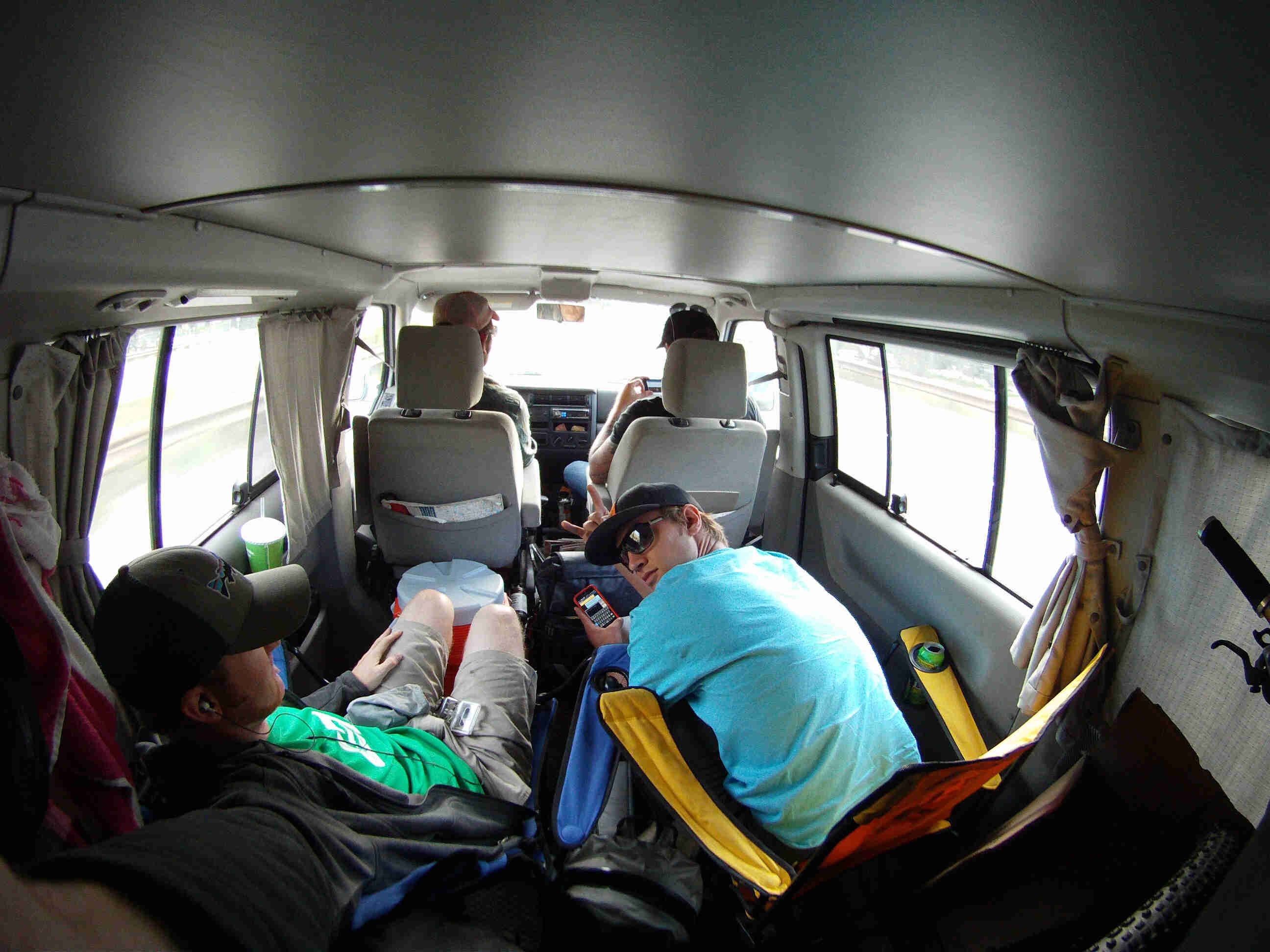 Back to front view of the inside of a van, with 2 people sitting in back seats and 2 people sitting in front seats