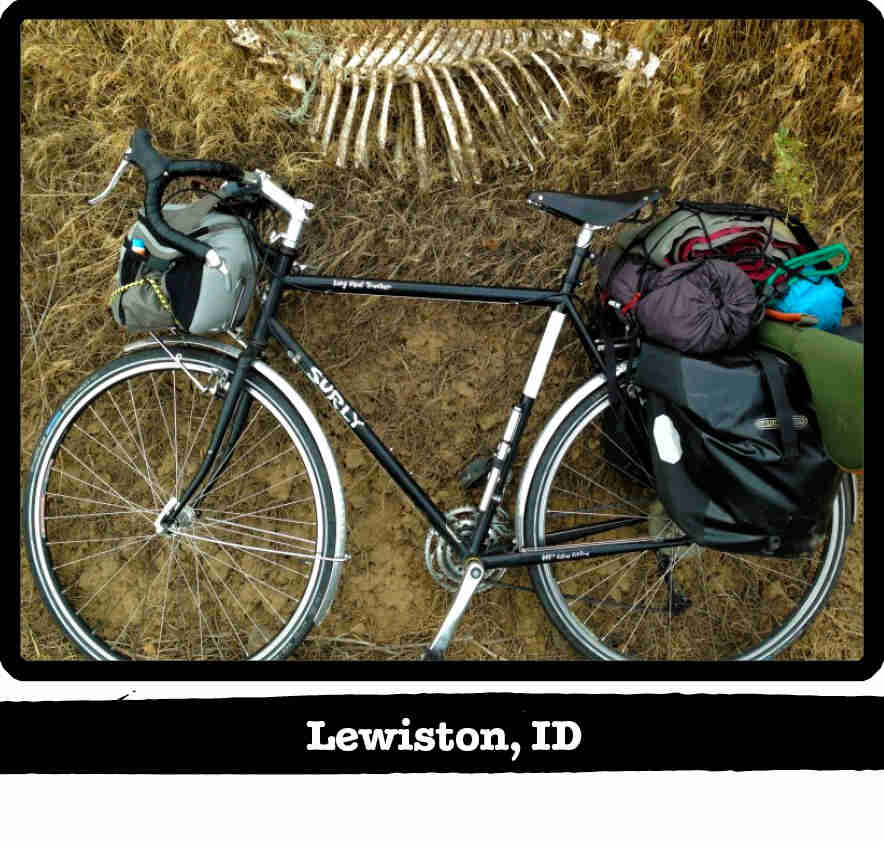 Downward view of a green Surly Long Haul Trucker bike, laying on right side in grass - Lewiston, ID banner below image