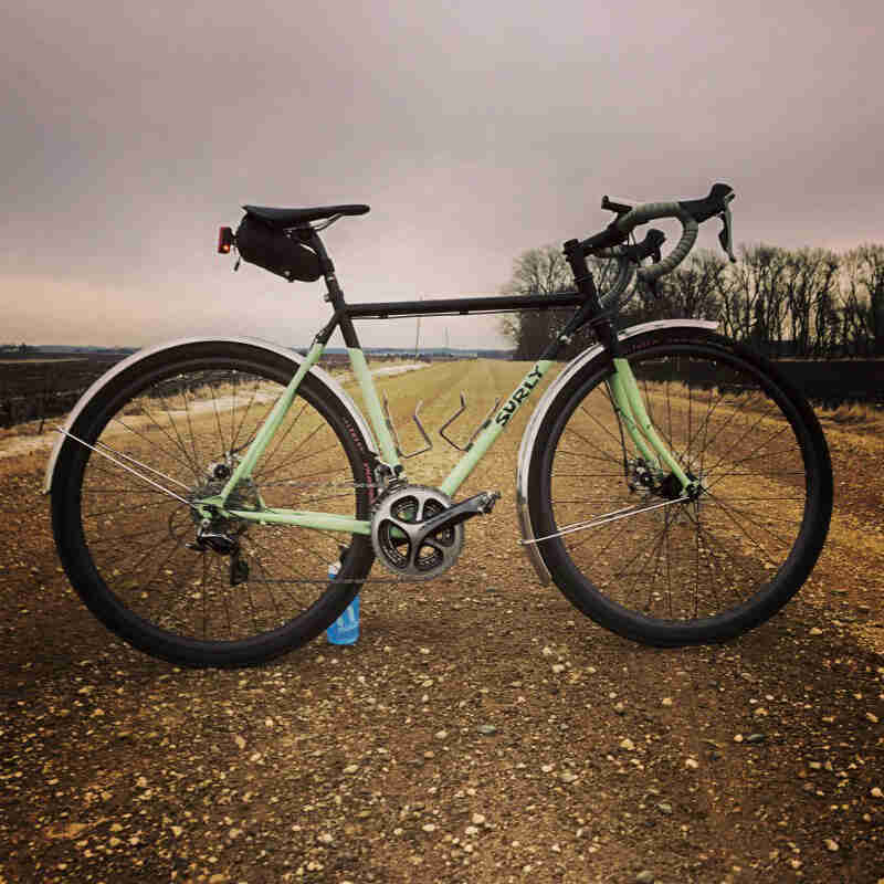 Right profile of a Surly bike standing across a gravel country road
