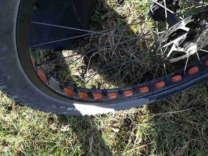 Downward, left side view of the front wheel from black Surly Pugsley fat bike