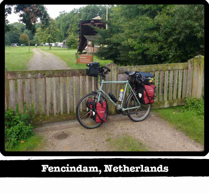 Left profile of a Surly Long Haul Trucker bike, mint, leaning on a wood gate - Fencindam, Netherlands tag below image