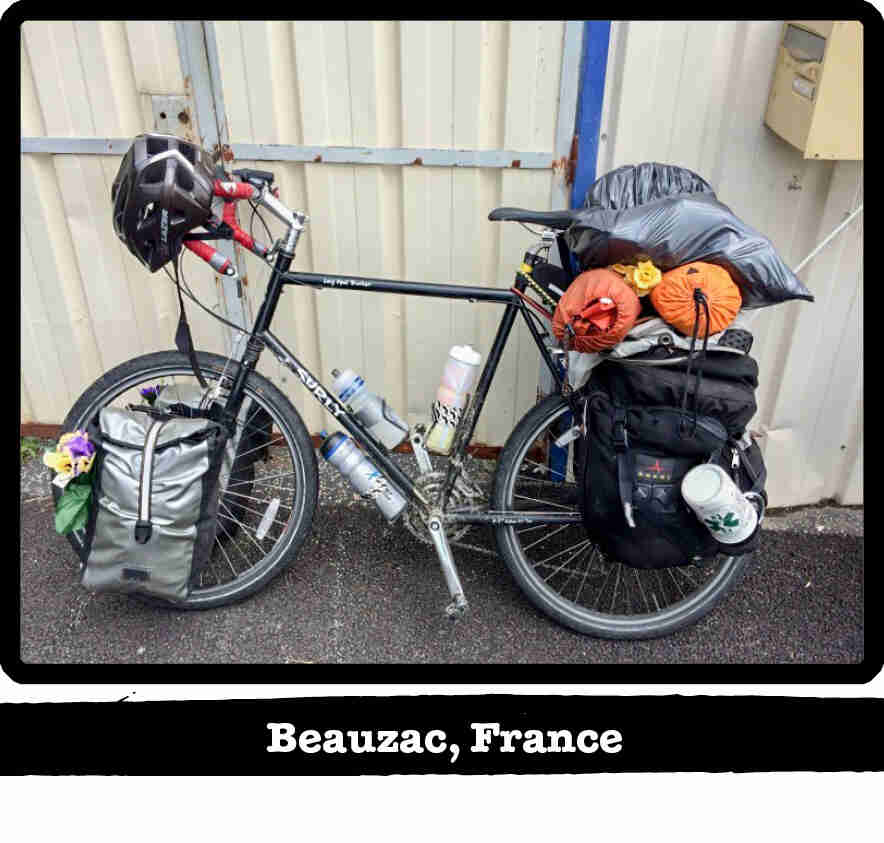 Left side view of a black Surly Long Haul Trucker bike with gear, leaning on a wall - Beauzac, France banner below image