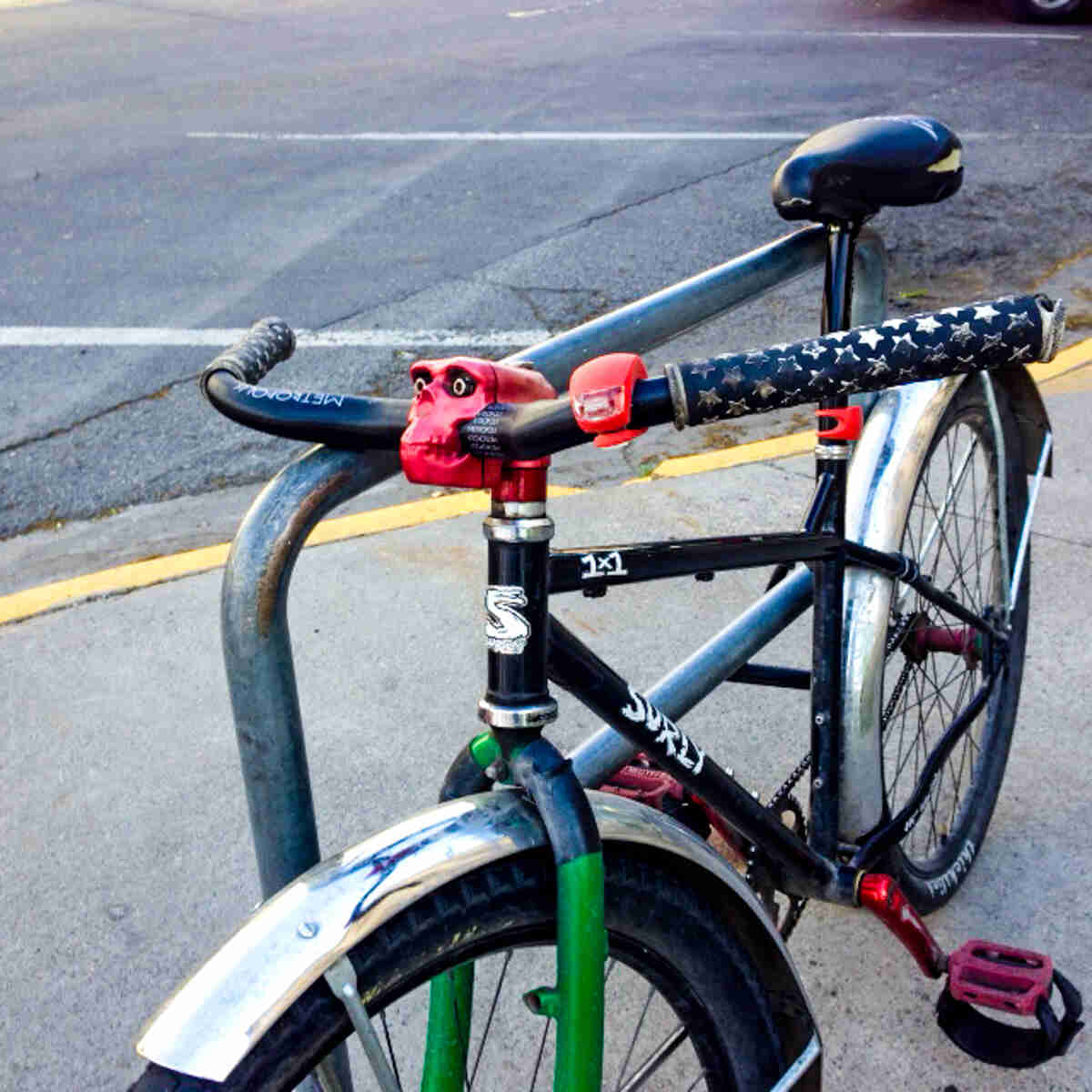 Cropped view of a the front of a black Surly 1x1 bike, with a red skeleton, handlebar neck
