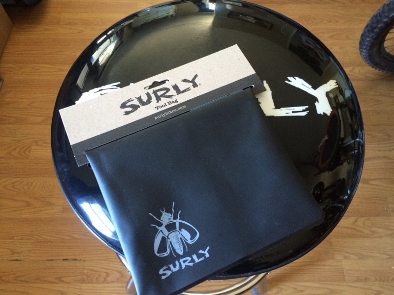 Downward view of a Surly tool bag, black, on a barstool seat