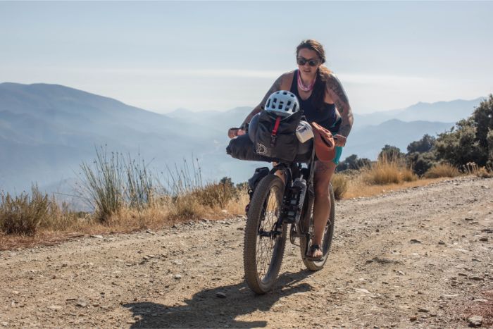 Cyclist rides up a gravel road in the mountains