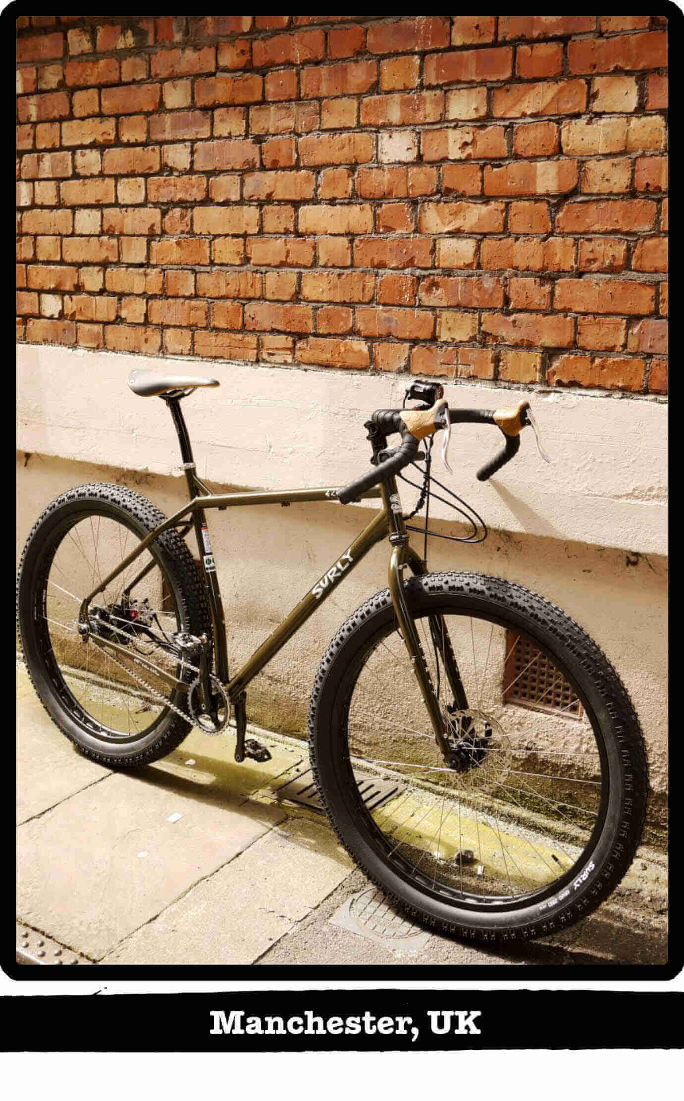 Right side view of a Surly ECR fat bike on sidewalk, leaning against a wall - Manchester, UK tag below image