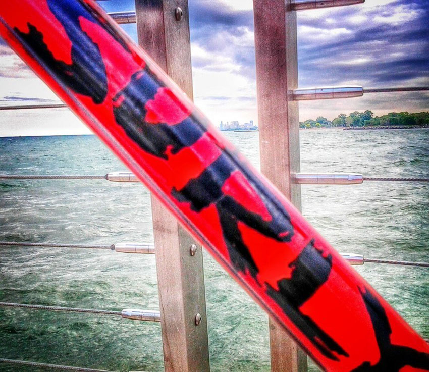 Zoomed in, close up view of a Surly sticker, on the down tube of a red Surly Pacer bike, with a bay in the background