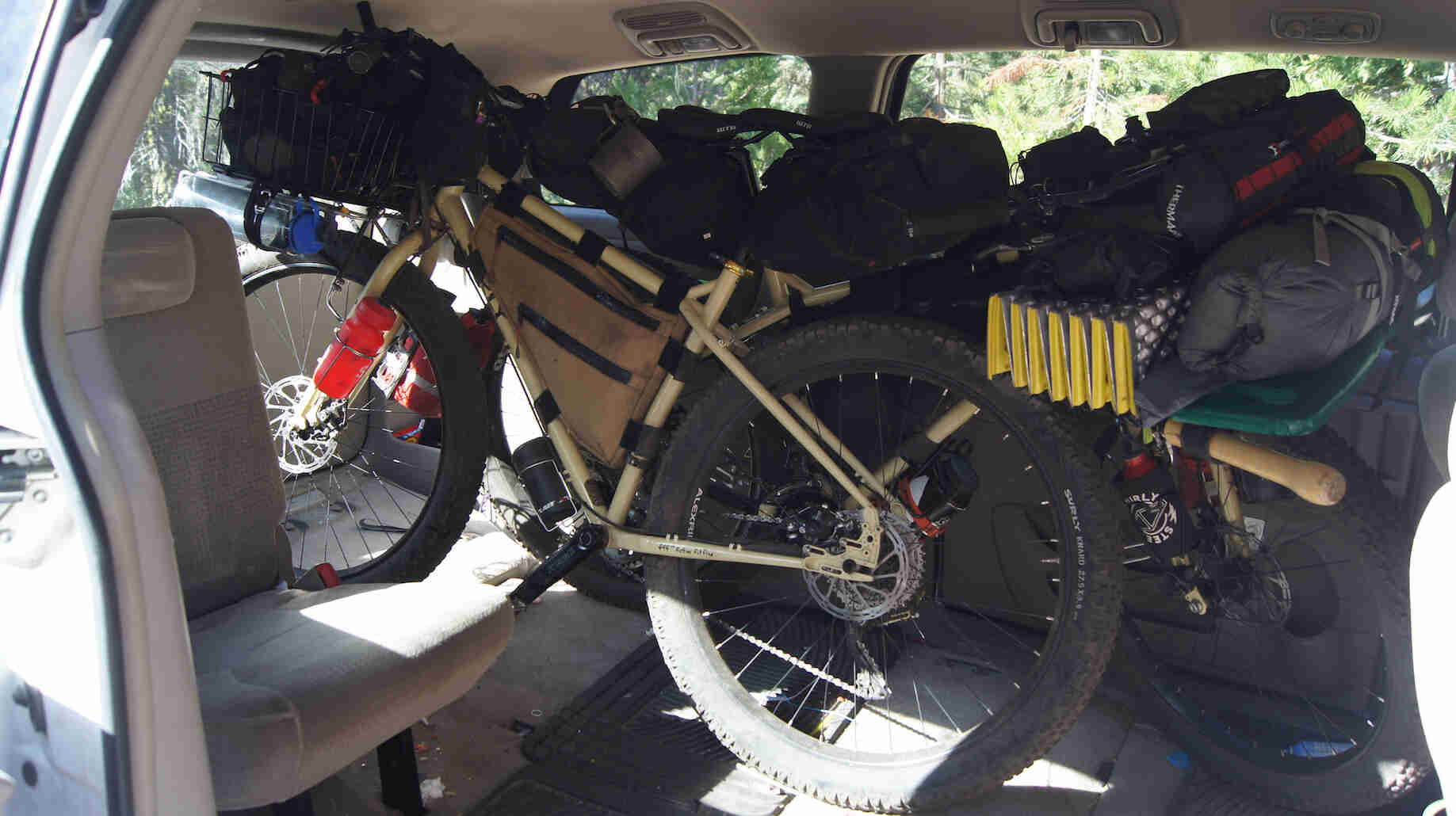 Left side view of a Surly bike, inside of a minivan with camping gear