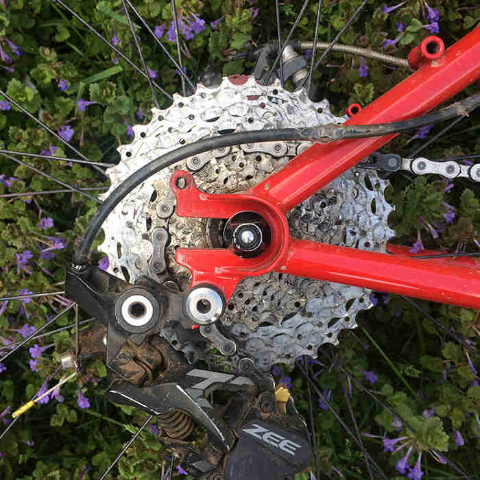Close up view of the rear drop outs, cassette and derailleur of a Surly Krampus bike, red