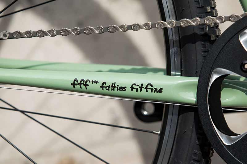 ミントカラーの Surly 自転車の fff tm - fatties fit fine ステッカーが貼られているドライブ側チェーンステーのアップ