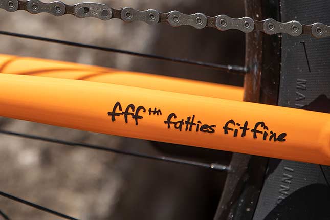オレンジの Surly 自転車のチェーンステーに貼られた fff ™ fatties fit fine ステッカーと後輪の一部
