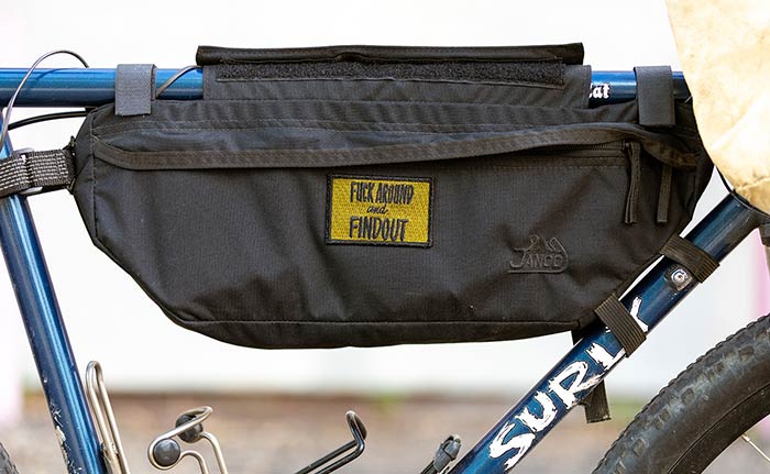 Side-view showing frame bag with yellow patch applied, blue frame and white Surly decal and two water bottle cages