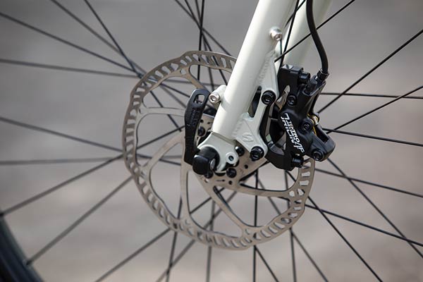 Zoom in of the front brake disc and caliper on the fork of a Surly Big Easy bike