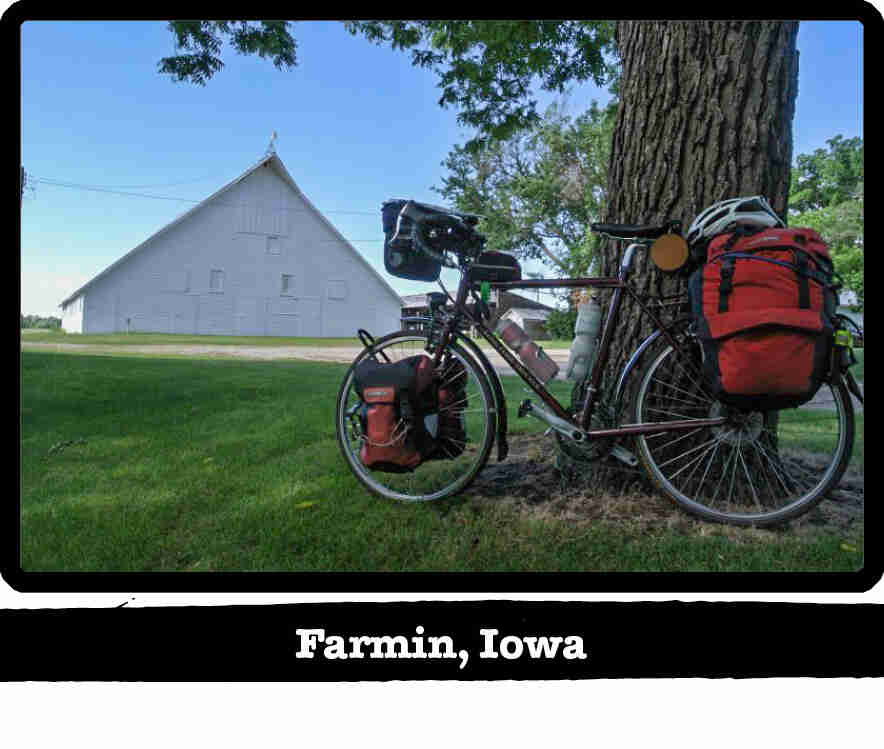 Left profile of a Surly Long Haul Trucker bike, tan, leaning on a tree on a farm - Farmin, IA tag below image