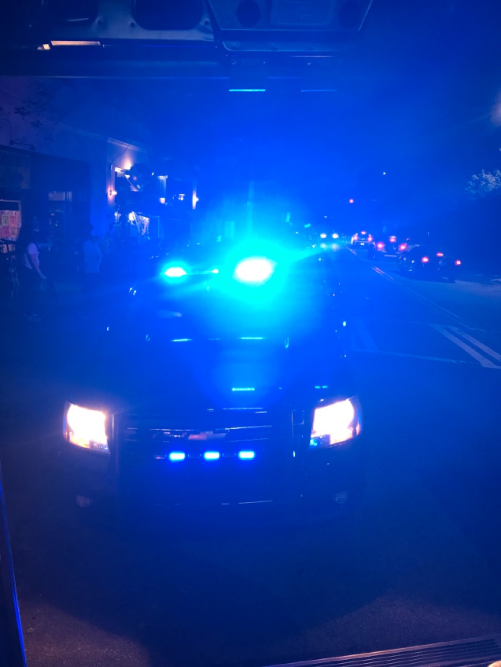 Front view of a police car on the street with it's light on at night