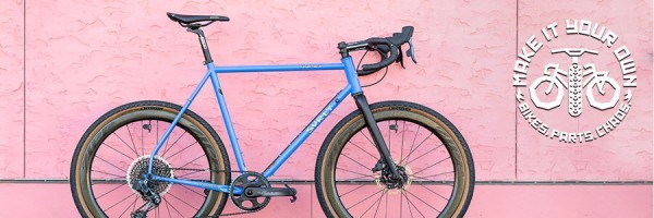 ピンクの漆喰の壁にたてかけたペリー ウィンクルズ スパークルカラーの Surly Midnight Special 自転車