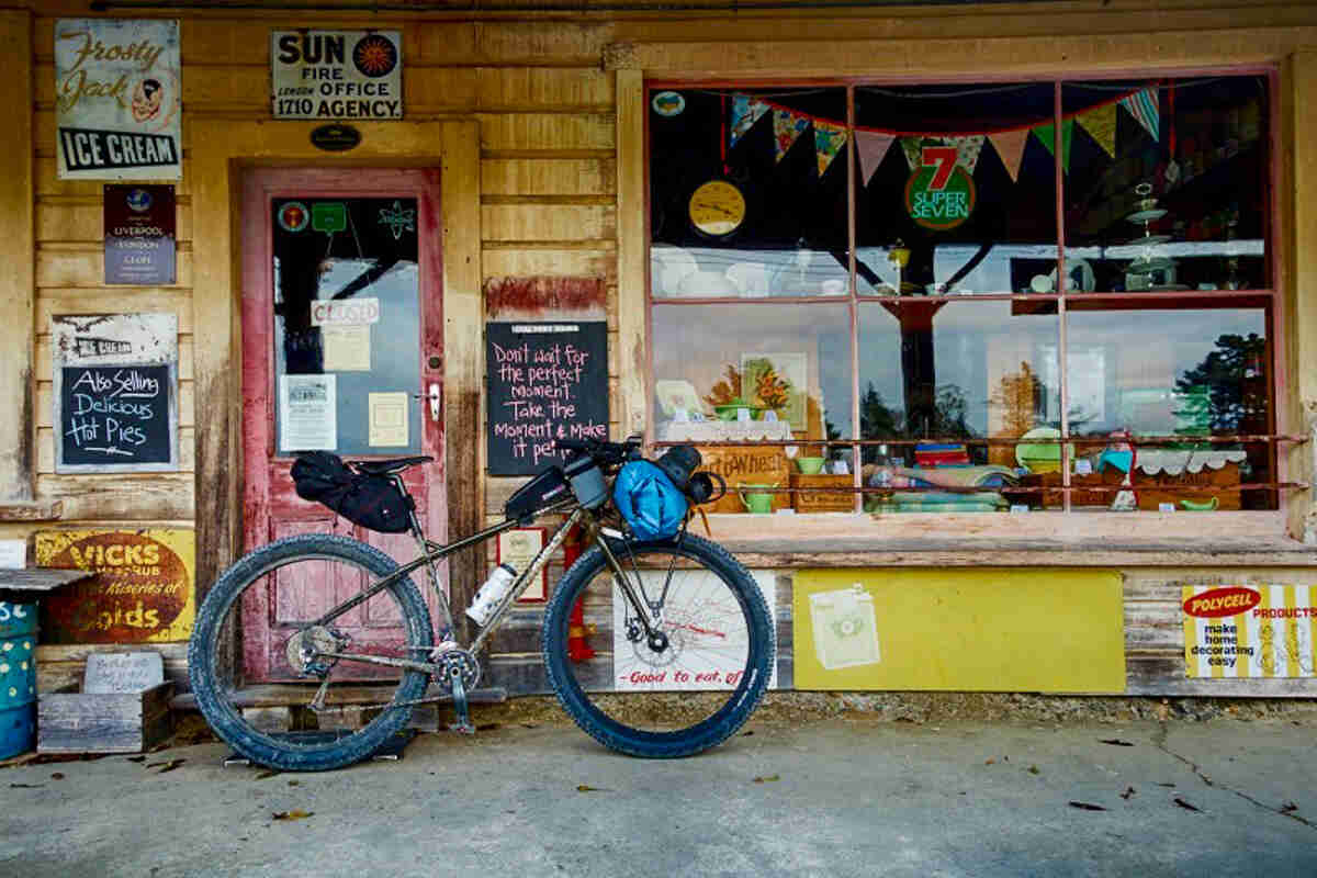 Right side view of a Surly bike loaded with gear, parked in front of an old storefront