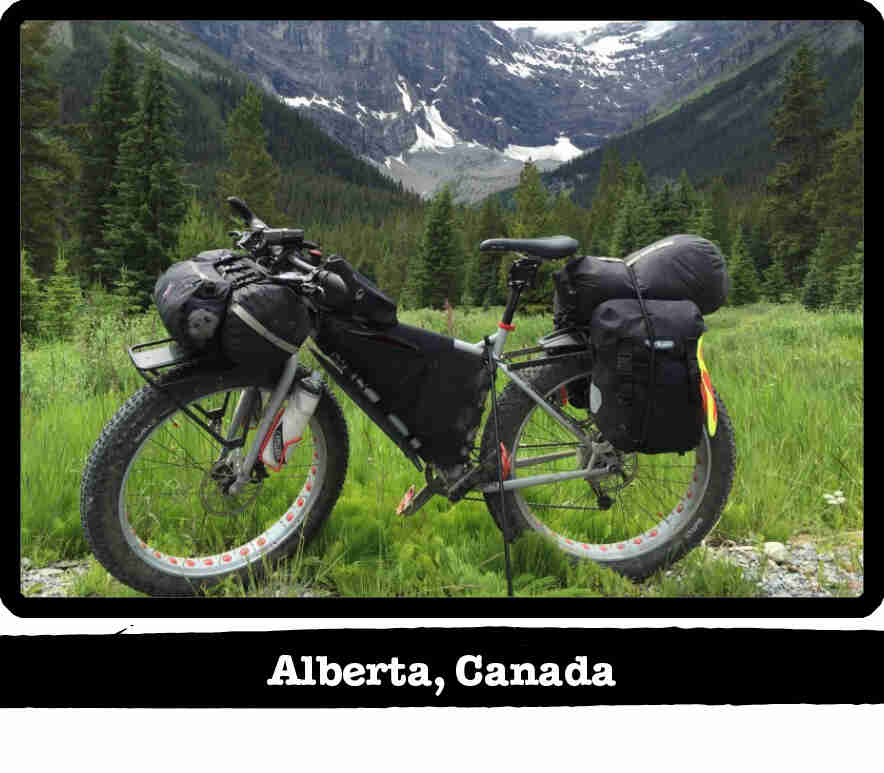 Left side view of a Surly fat bike, gray, on a field in the mountains - Alberta, Canada tag below image