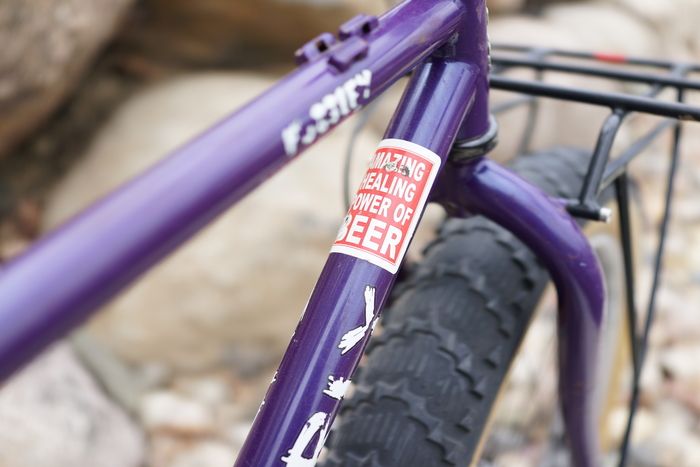 Close up partial view of the front of a purple Surly Pugsley fat bike top tube and down tube with white/red sticker