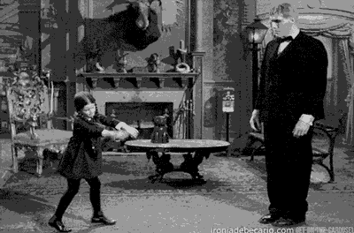 Looped GIF of Wednesday Addams dancing in front of Lurch from the Addams Family TV show 