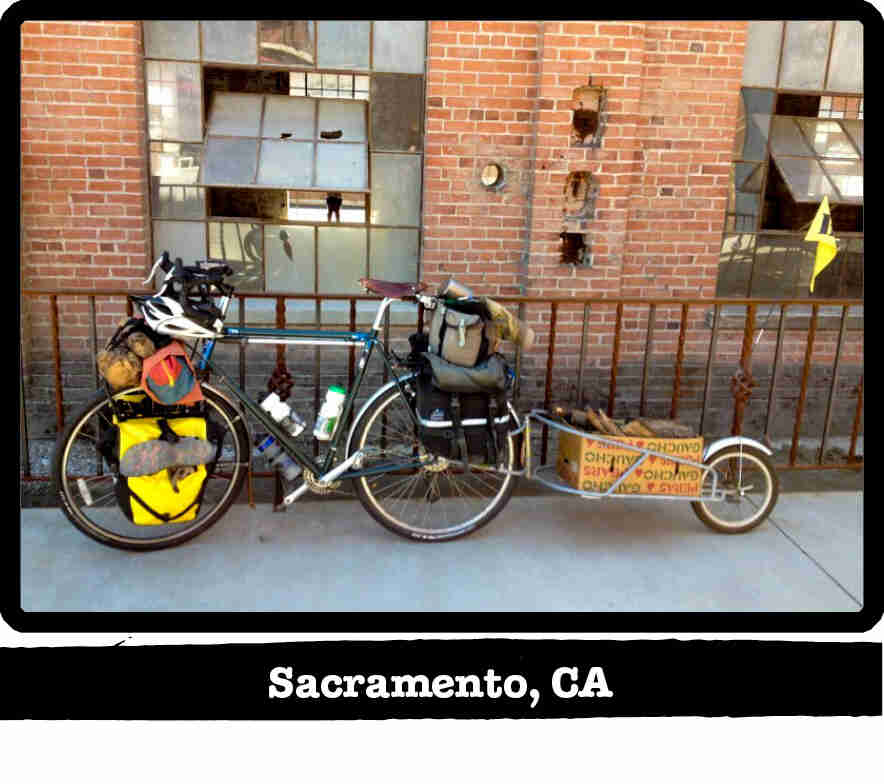Left side view of a green Surly Long Haul Trucker bike with a trailer, on a sidewalk - Sacramento, CA tag below image