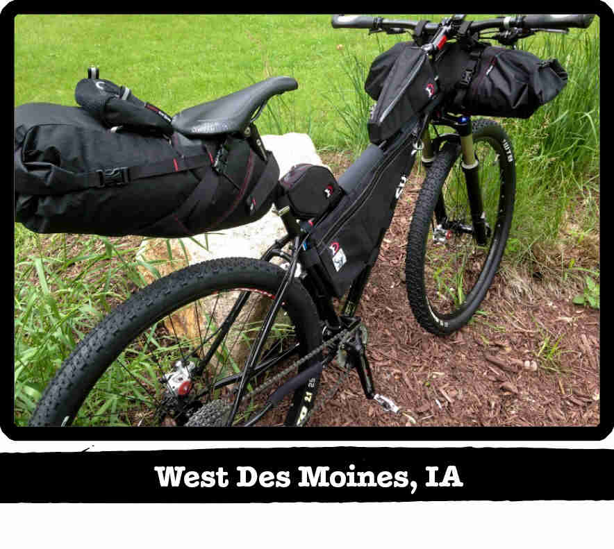 Right side rear view of a Surly Karate Monkey bike with gear, black, in tall grass - West Des Moines, IA tag below image