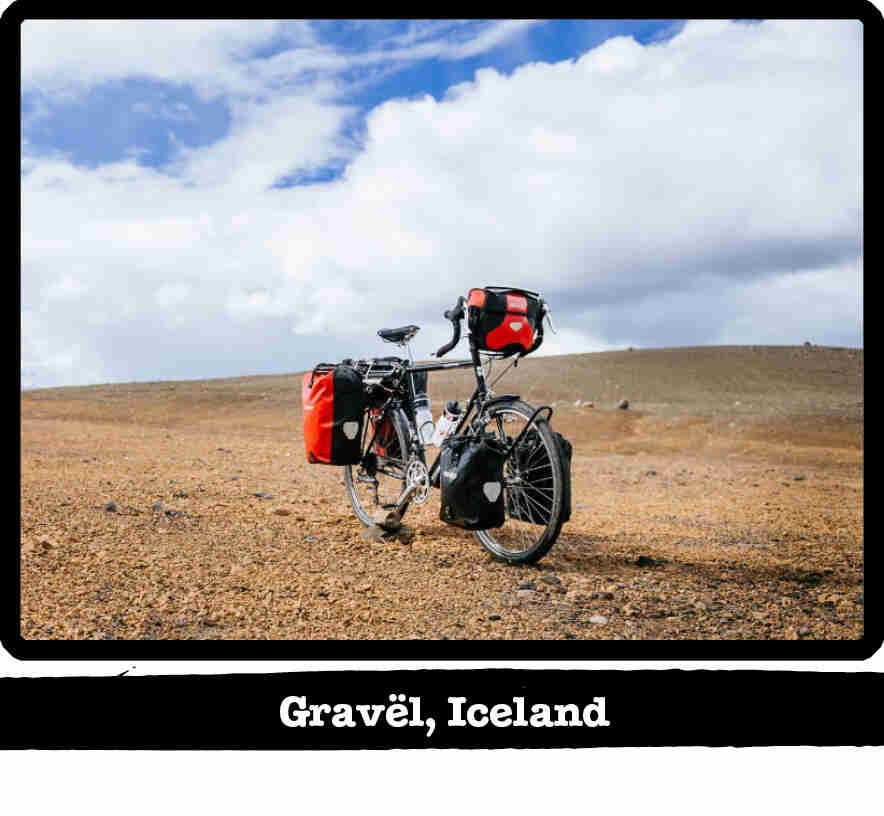 Front left view of a Surly Long Haul Trucker bike loaded with gear, in a pebble field-Gravel, Iceland banner below image