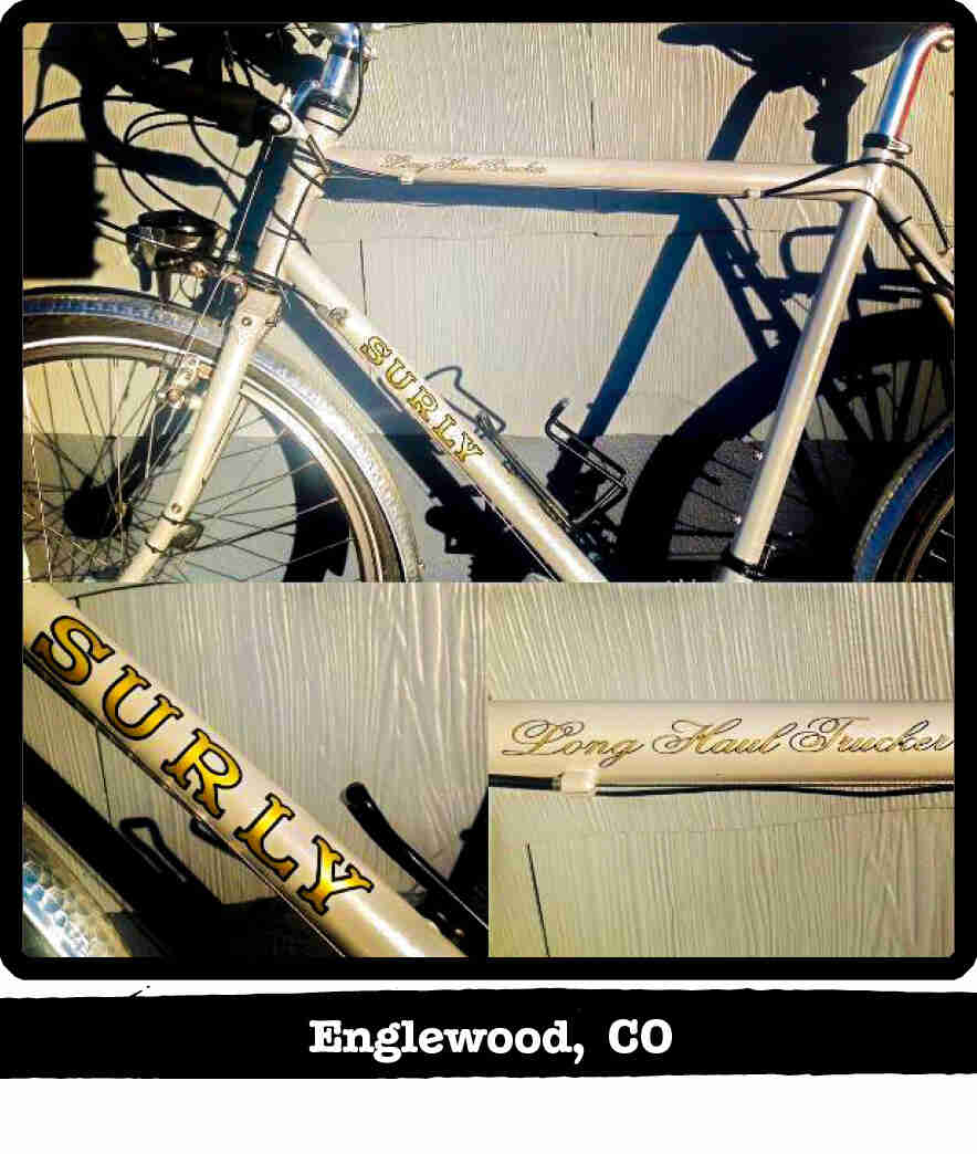 Left profile of a Surly Long Haul Trucker bike, tan, leaning of a wood-sided wall - Englewood, CO tag below image
